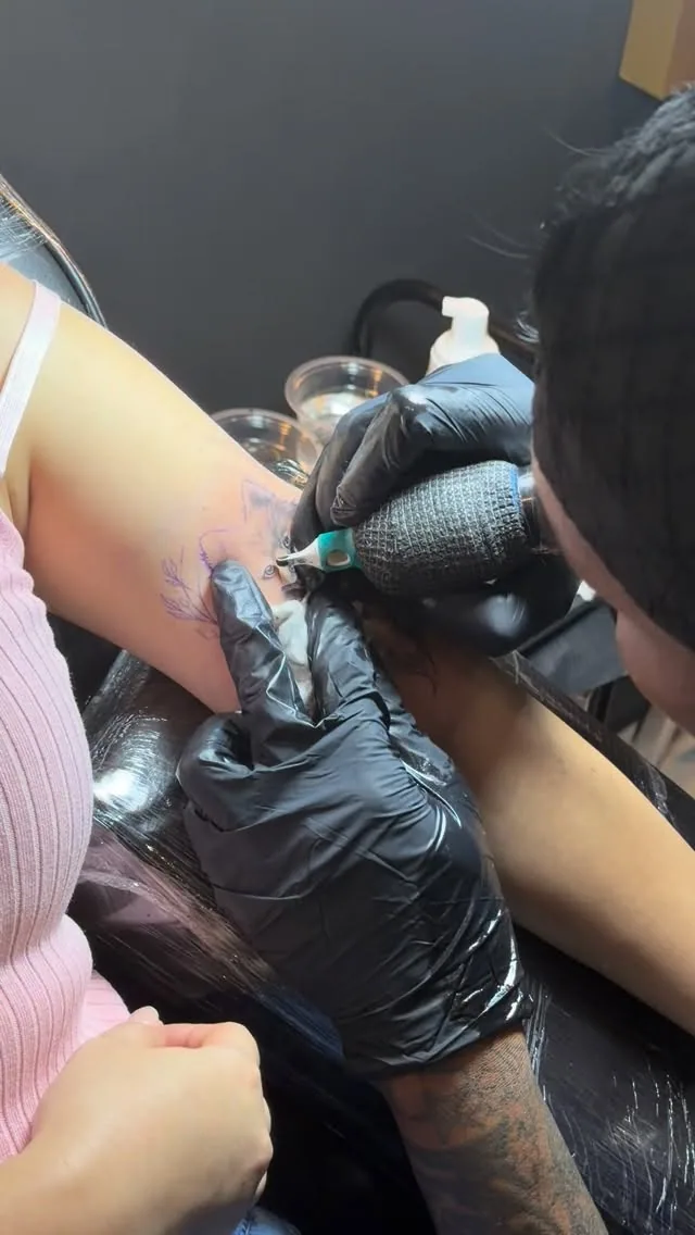 Close-up of a Mafia Ink artist working on a client’s arm tattoo