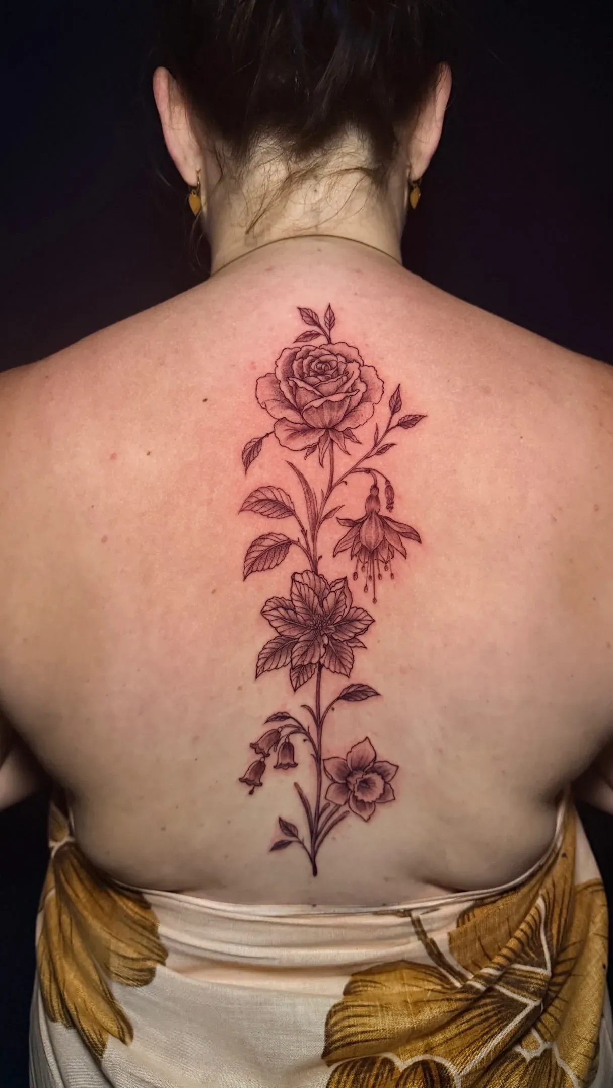 Red floral backpiece tattoo by The Mafia Ink Bali